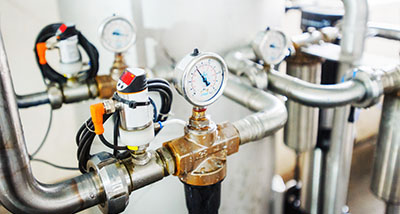 industrial piping system with pressure gauges and valves for fluid control