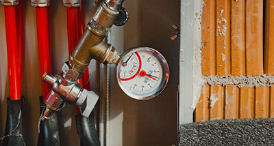 pressure gauge and plumbing system with red pipes for six water connections